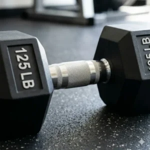Close-up detail of the chrome knurled handle on a professional 125 lb dumbbell for better grip.
