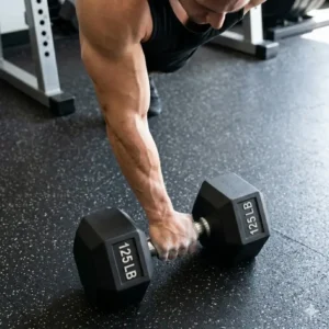 An experienced lifter preparing to perform a single-arm row using a 125 lb dumbbell.