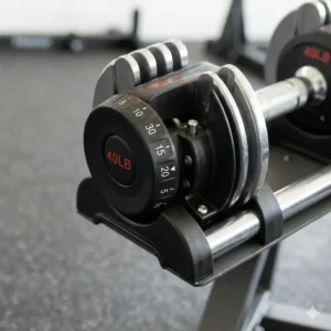 Close-up illustration of the dial mechanism on an adjustable dumbbell showing weight selection.